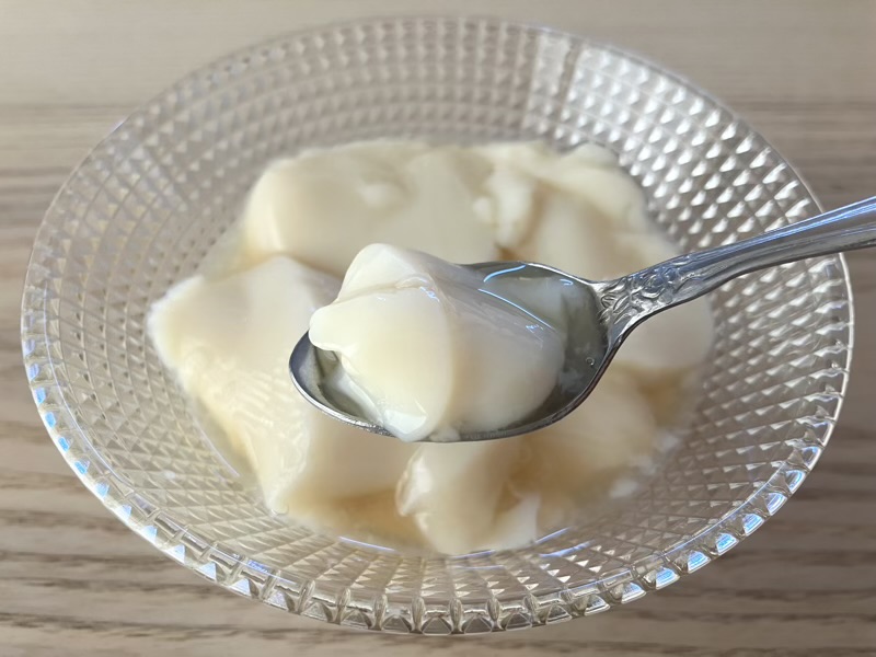 スプーンですくったシロップたっぷりの豆花を一口